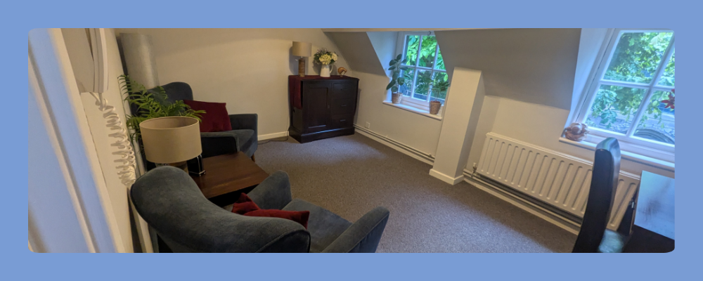A professional and warm individual therapy room at Snow Hill featuring comfortable seating and neutral decor.