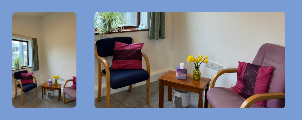 A private, peaceful counselling room in a Hammersmith community centre featuring two comfortable chairs, yellow flowers, and natural light for therapy sessions